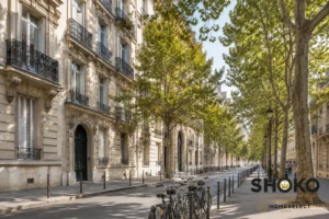 Tree-lined Parisian street in the 7th arrondissement with classic Haussmann buildings appealing to Scandinavian property buyers